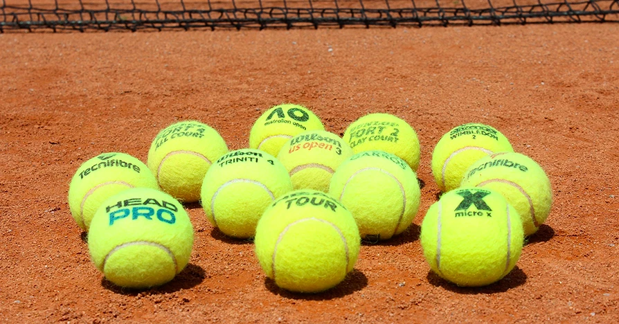 Tennisbälle auf Sandplatz