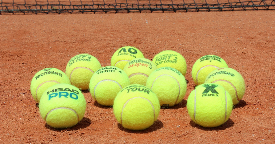 Tennisbälle auf Sandplatz